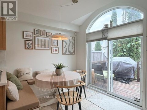 A living room with a white table and a couch with a green pillow on it.
