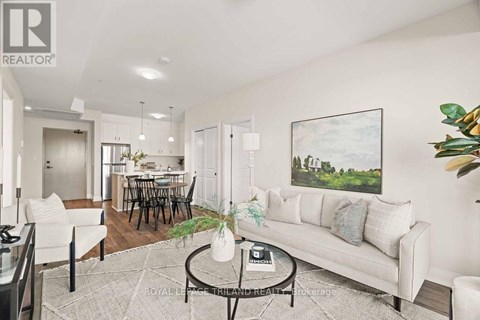 A living room with a white couch, a coffee table, and a painting on the wall.