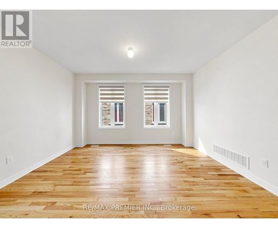 A spacious room with wooden floors and white walls.