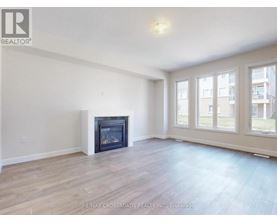A spacious living room with a fireplace and hardwood floors.