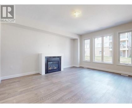 A spacious living room with a fireplace and hardwood floors.