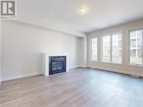 A spacious living room with a fireplace and hardwood floors.