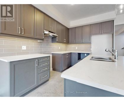 A kitchen with a sink, cabinets and a counter top.