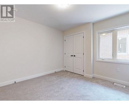 A bedroom with a white door and a window.