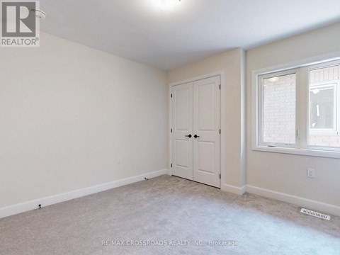 A bedroom with a white door and a window.