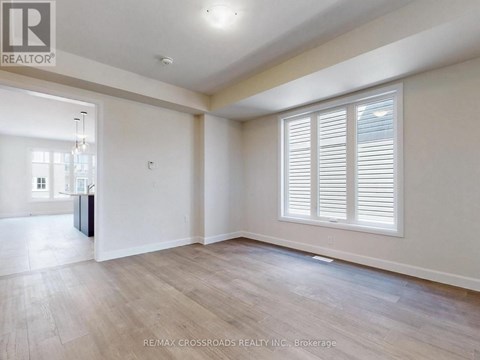 A spacious room with wooden flooring and white walls.