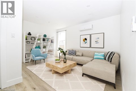 A living room with a grey couch, a blue chair, a wooden coffee table, and a bookshelf with various items.