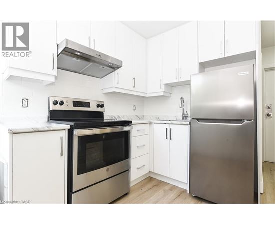 A modern kitchen with stainless steel appliances and white cabinetry.