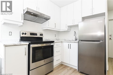 A modern kitchen with stainless steel appliances and white cabinetry.