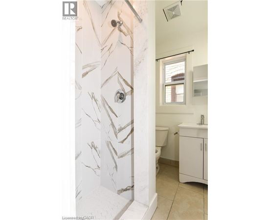 A bathroom with a marble patterned wall.