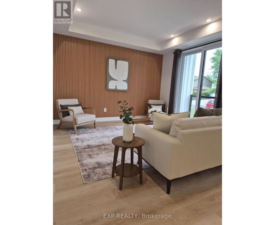 A living room with a white couch, a wooden coffee table, and a large window.