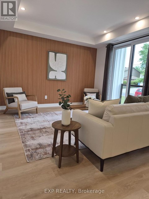 A living room with a white couch, a wooden coffee table, and a large window.
