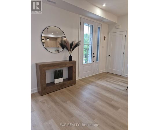 A realtor photo of a room with a wooden fireplace and a round mirror on the wall.
