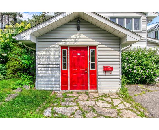 A small house with a red door and mailbox.