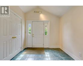 A hallway with a white door and a white wall.