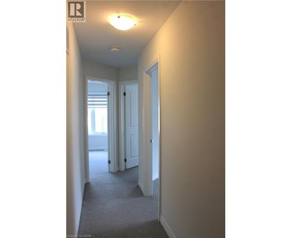 A hallway with a door on the right and a window on the left.