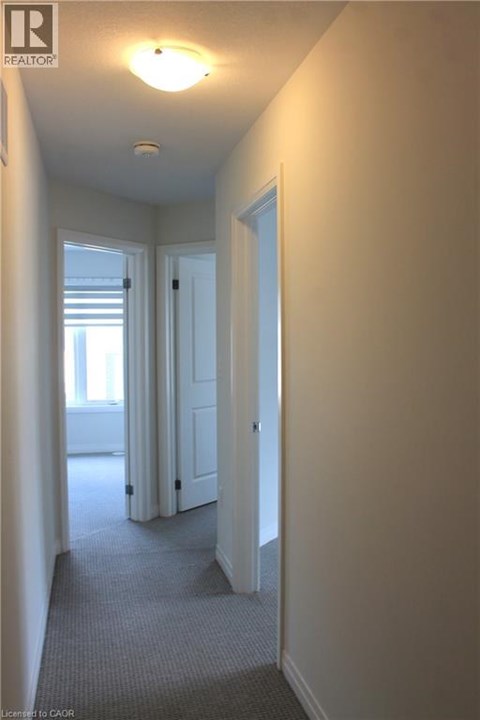 A hallway with a door on the right and a window on the left.