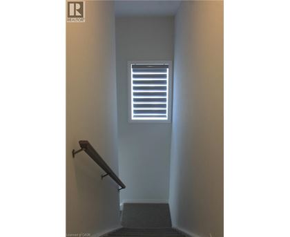 A stairway leading to a window with blinds.
