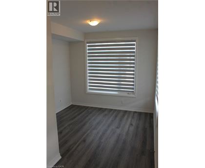 A room with a window covered by white blinds.