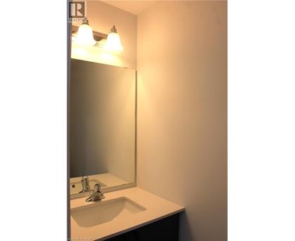 A bathroom sink under a mirror with lights above it.