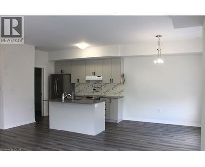A kitchen with a marble countertop and a wooden floor.