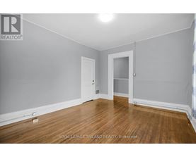 A room with wooden flooring and two doors.