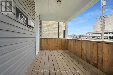 A balcony with a wooden floor and a metal wall.