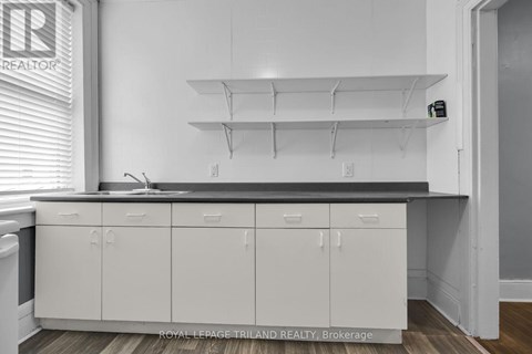 A kitchen with white cabinets and a black countertop.