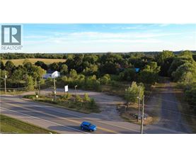 A blue car is driving on a road with a REALTOR® logo in the corner.