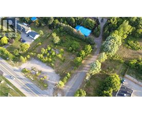 An aerial view of a green area with a blue building and a parking lot.