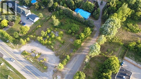 An aerial view of a green area with a blue building and a parking lot.