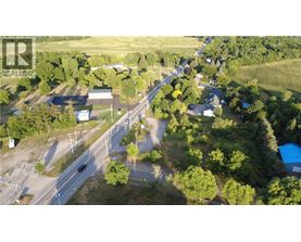 A bird's eye view of a road intersection surrounded by trees and buildings.