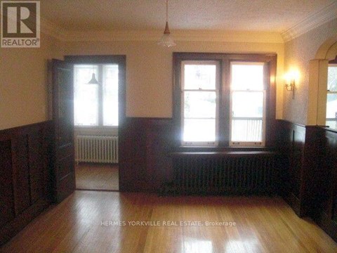 A room with wood floors and a window with a white frame.