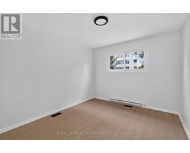 A room with a window showing a building outside.