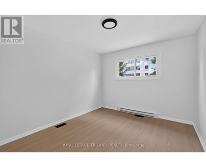 A room with a window showing a building outside.