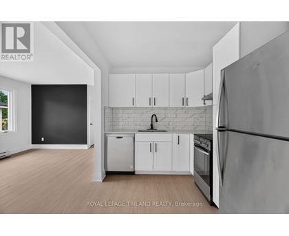 A kitchen with white cabinets and a refrigerator.