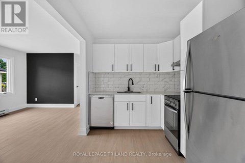 A kitchen with white cabinets and a refrigerator.