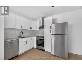 A modern kitchen with stainless steel appliances and white cabinets.