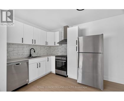 A modern kitchen with stainless steel appliances and white cabinets.