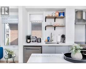 A modern kitchen with white cabinets and a black countertop.