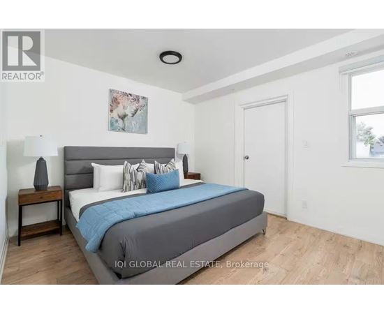A bedroom with a bed, nightstand, and lamp.
