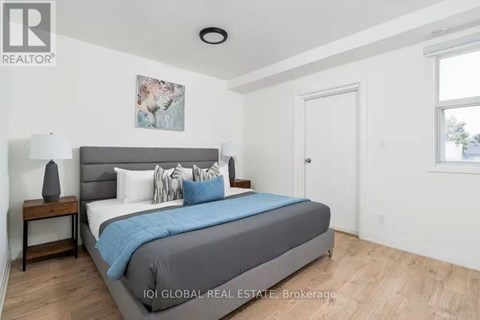 A bedroom with a bed, nightstand, and lamp.