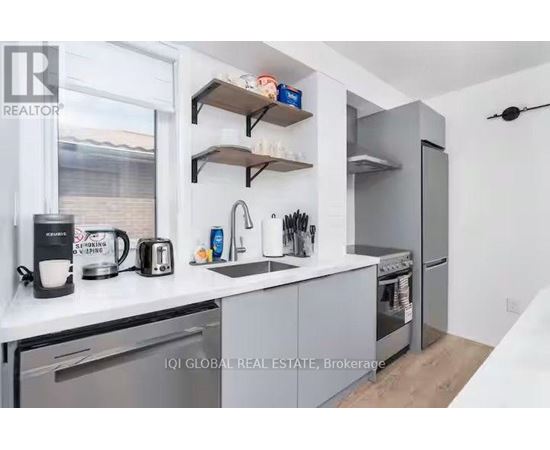 A modern kitchen with a stainless steel refrigerator, a toaster, and a coffee maker.