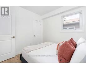 A bedroom with a bed, a window, and a door.