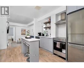 A modern kitchen with stainless steel appliances and a wooden floor.