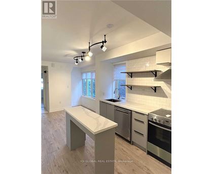 A modern kitchen with stainless steel appliances and a marble island.