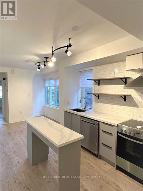 A modern kitchen with stainless steel appliances and a marble island.