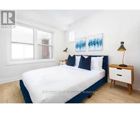 A bedroom with a bed, nightstand, and lamp.