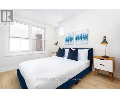 A bedroom with a bed, nightstand, and lamp.
