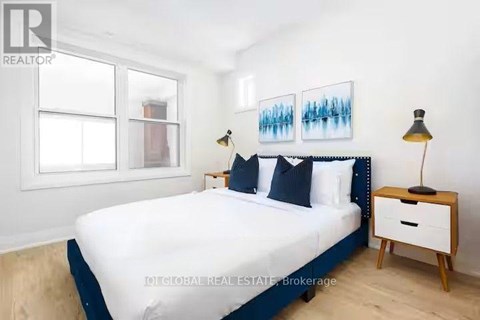 A bedroom with a bed, nightstand, and lamp.